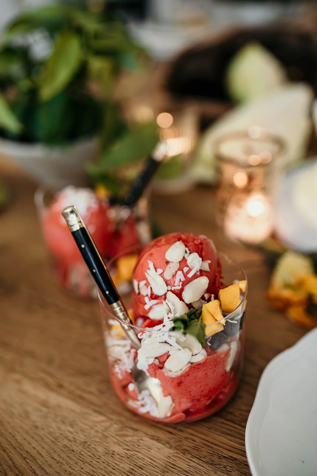 Freezing Point Co frozen dessert topped with almonds and fresh fruit, served in a glass